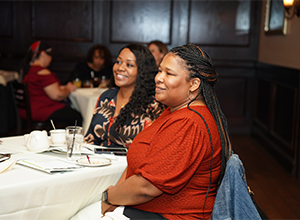 Two women at a table smiling