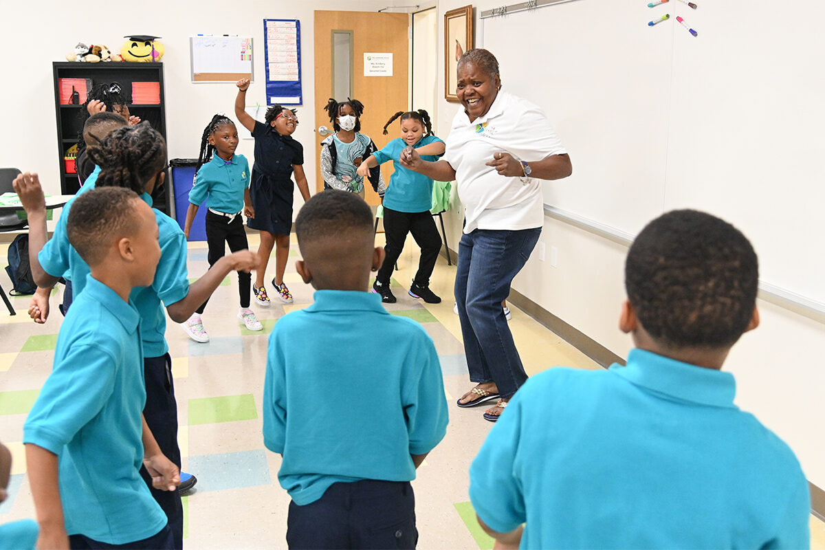 A teacher leads students in dancing