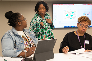 Three women working through problems. 